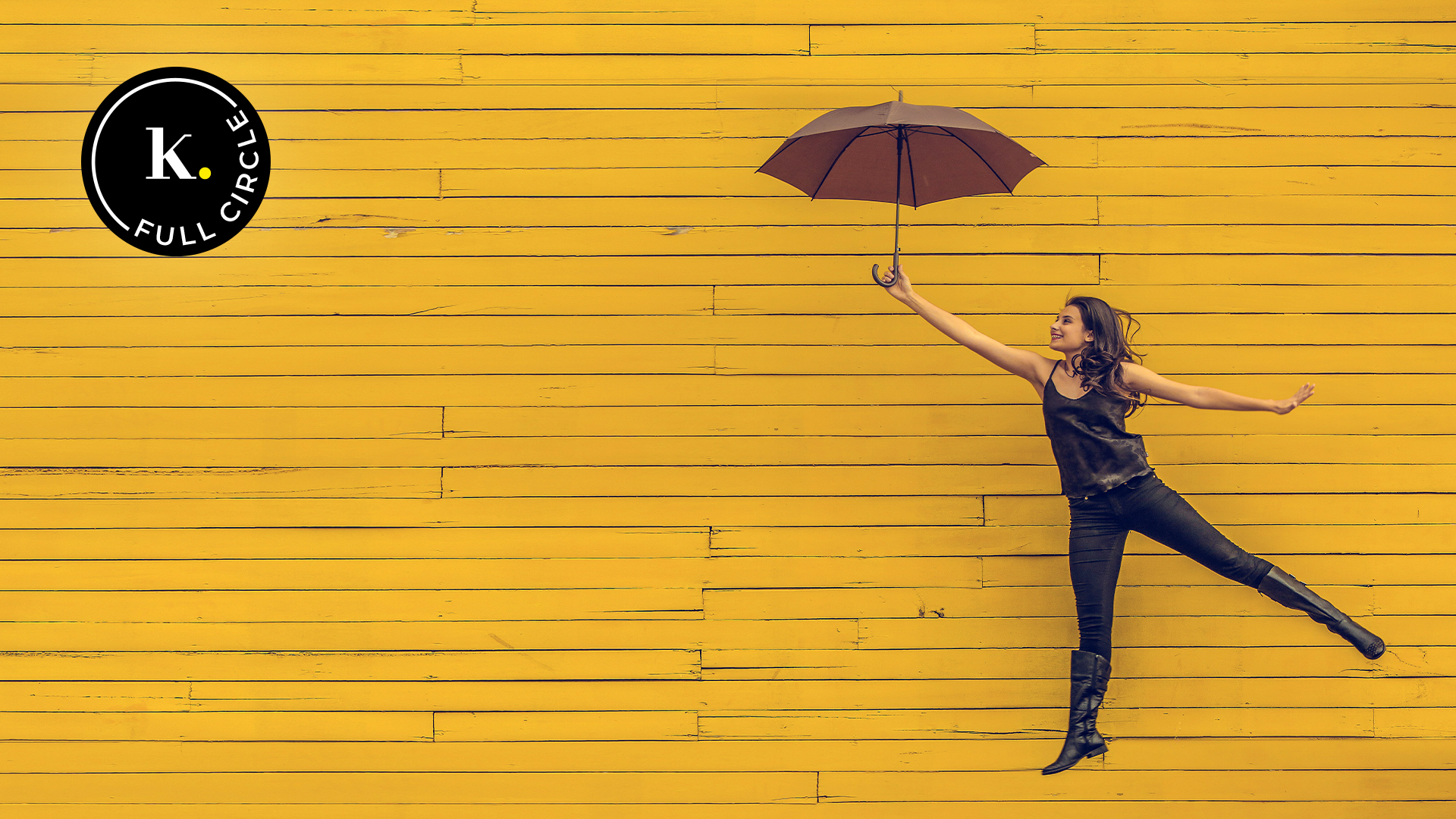 Image of a happy woman holding an umbrella and jumping
